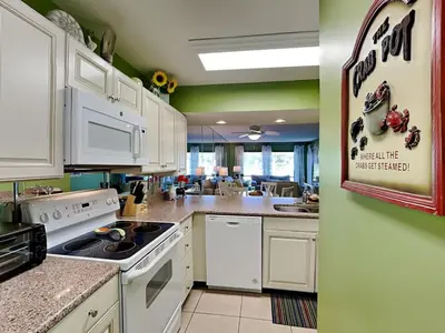 a kitchen with white appliances and green walls at Edgewater Villa 1702 in Panama City Beach