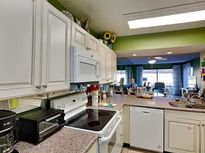 a kitchen with white cabinets and a stove top oven at Edgewater Villa 1702 in Panama City Beach