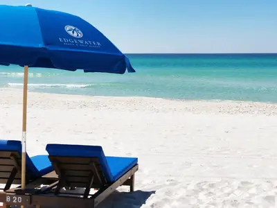 two chairs and an umbrella on a beach at Edgewater Villa #2406 in Panama City Beach