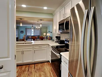 a kitchen with white cabinets and a stainless steel refrigerator at Edgewater Villa #2406 in Panama City Beach