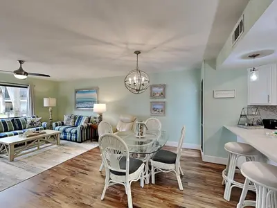 a kitchen and living room with a glass table and chairs at Edgewater Villa #2406 in Panama City Beach