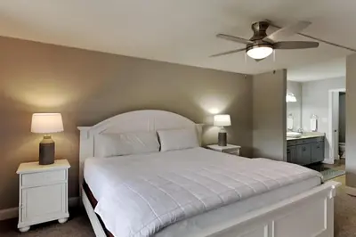 a bedroom with a white bed and a ceiling fan at Edgewater Villa #2301 in Panama City Beach