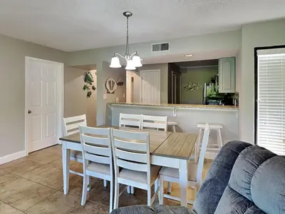 a dining room and kitchen with a table and chairs at Edgewater Villa #2301 in Panama City Beach