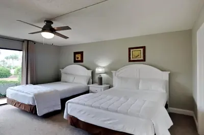 a bedroom with two beds and a ceiling fan at Edgewater Villa #2301 in Panama City Beach