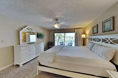 a bedroom with a large white bed and a television at Edgewater Villa #2407 in Panama City Beach