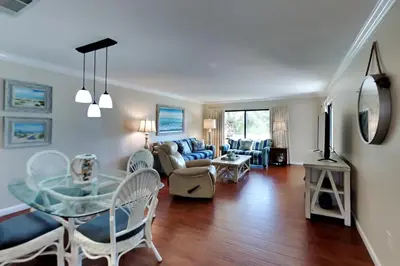a living room with a glass table and chairs at Edgewater Villa #2409 in Panama City Beach