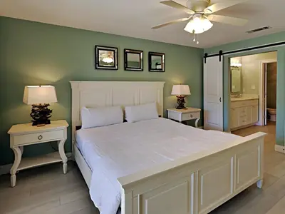 a bedroom with a large white bed with two tables at Edgewater Villa #3315 in Panama City Beach