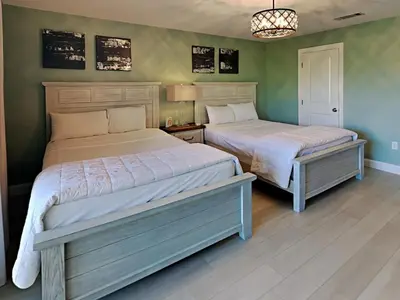 two beds in a bedroom with green walls at Edgewater Villa #3315 in Panama City Beach