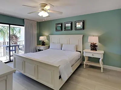 a bedroom with a white bed and two tables with lamps at Edgewater Villa #3315 in Panama City Beach