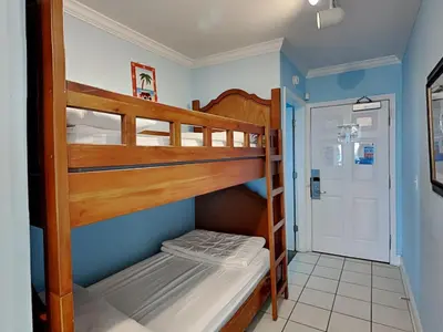 two bunk beds in a small room with a door at Emerald Beach #1127 in Panama City Beach