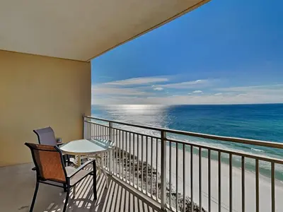 a balcony with a table and chairs and the ocean at Emerald Beach #1127 in Panama City Beach