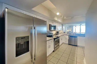 a large kitchen with a stainless steel refrigerator at Emerald Beach #1030 in Panama City Beach