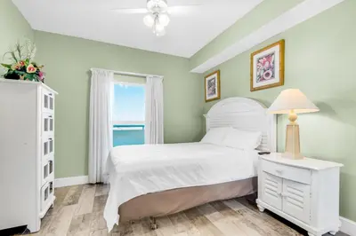 a bedroom with a white bed and a window at Majestic Beach Towers 1-1210 in Panama City Beach