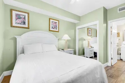a bedroom with a white bed and green walls at Majestic Beach Towers 1-1210 in Panama City Beach