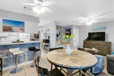 a living room with a table and chairs at Happy Heron, Steps to Beach in Panama City Beach