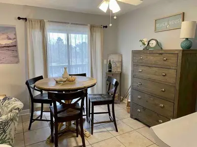 a dining room with a table and chairs and a dresser at Happy Heron, Steps to Beach in Panama City Beach