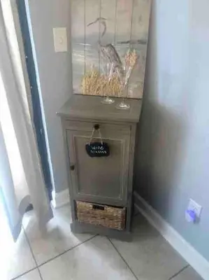 a small table with a bird painting on the wall at Happy Heron, Steps to Beach in Panama City Beach