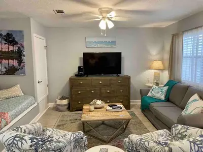 a living room with a couch and a flat screen tv at Happy Heron, Steps to Beach in Panama City Beach
