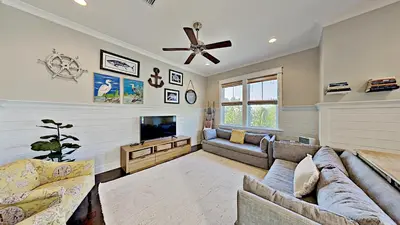 a living room with a couch and a tv at The Den on 30A in Inlet Beach