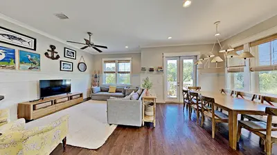 a living room with a table and a dining room at The Den on 30A in Inlet Beach