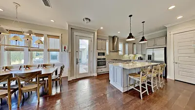 a kitchen with a large island with a table and chairs at The Den on 30A in Inlet Beach