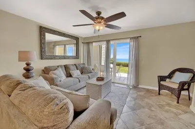 a living room with a couch and a ceiling fan at Gulf-Front Seacrest Beach Condo w/ Private Access in Panama City Beach