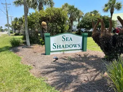 a sign for a sea shadows sign in a yard at Gulf-Front Seacrest Beach Condo w/ Private Access in Panama City Beach