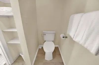 a bathroom with a white toilet and a towel at Gulf-Front Seacrest Beach Condo w/ Private Access in Panama City Beach