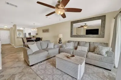 a living room with a couch and a ceiling fan at Gulf-Front Seacrest Beach Condo w/ Private Access in Panama City Beach