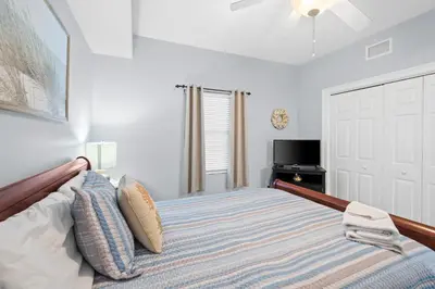 a bedroom with a large bed and a tv at Quiet East End Gulf-Front Condo w/ Heated Pool & Balcony in Panama City Beach