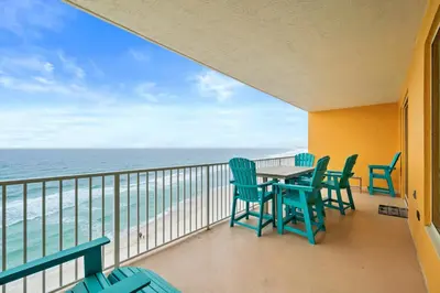 a balcony with chairs and a table and the ocean at Quiet East End Gulf-Front Condo w/ Heated Pool & Balcony in Panama City Beach