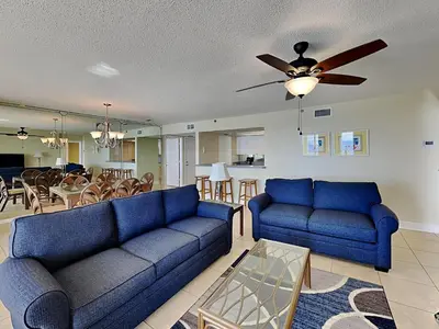 a living room with blue couches and a dining room at Long Beach Resort Tower II #904 in Panama City Beach