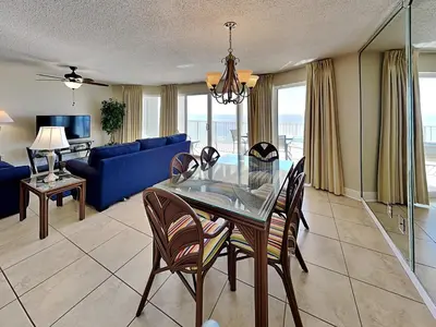 a living room with a glass table and a blue couch at Long Beach Resort Tower II #904 in Panama City Beach