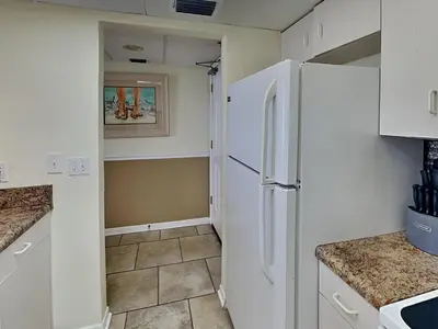 a kitchen with white cabinets and a refrigerator at Long Beach Resort Tower III #905 in Panama City Beach