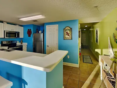 a kitchen with blue and green walls and a refrigerator at Majestic Beach Towers I #405 in Panama City Beach