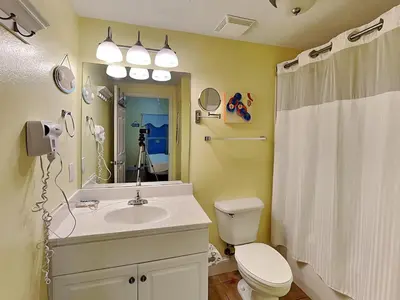 a bathroom with a sink and a toilet and a mirror at Majestic Beach Towers I #405 in Panama City Beach