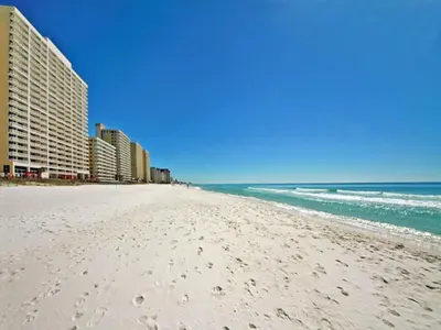 a white beach with buildings and the ocean at Majestic Beach Towers I #1109 in Panama City Beach