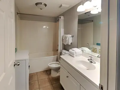 a bathroom with a sink and a toilet and a mirror at Majestic Beach Towers I #1109 in Panama City Beach