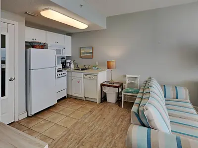 a living room with a couch and a kitchen at Majestic Beach Towers I #1109 in Panama City Beach