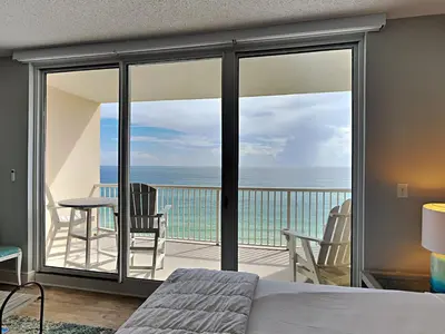 a bedroom with a balcony with a view of the ocean at Majestic Beach Towers I #1109 in Panama City Beach