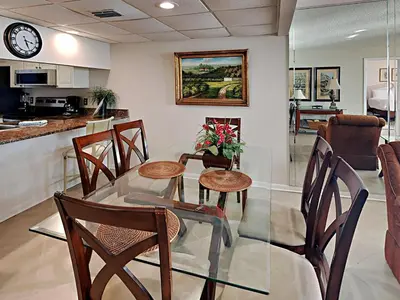 a dining room with a glass table and chairs at Edgewater Tower II 509 in Panama City Beach