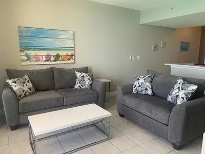 a living room with two couches and a coffee table at Majestic Beach Towers I #1410 in Panama City Beach