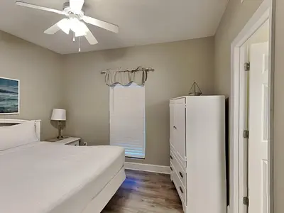 a bedroom with a white bed and a ceiling fan at Majestic Beach Towers I #1410 in Panama City Beach