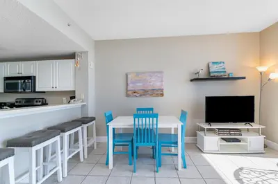 a kitchen with a table and chairs and a television at Majestic Beach Towers I #1410 in Panama City Beach