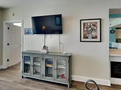 a flat screen tv on a white wall in a living room at Majestic Beach Towers II #1204 in Panama City Beach