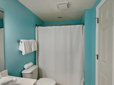 a bathroom with a white shower curtain and a toilet at Majestic Beach Towers II #1204 in Panama City Beach