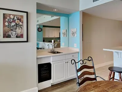 a kitchen with a sink and a table with a chair at Majestic Beach Towers II #1204 in Panama City Beach
