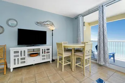 a dining room with a television and a table with chairs at Majestic Beach Towers I #1105 in Panama City Beach