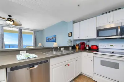 a kitchen with white cabinets and a sink at Majestic Beach Towers I #1105 in Panama City Beach