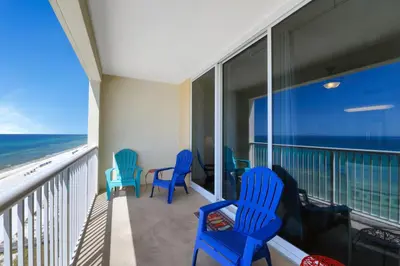 a balcony with blue chairs and a view of the ocean at Majestic Beach Towers I #1105 in Panama City Beach